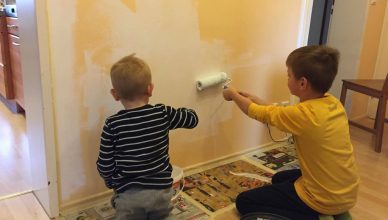 Die Jungs streichen eine Wand.