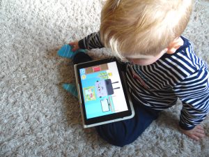 Der Junge spielt App Lingumi am Tablet.